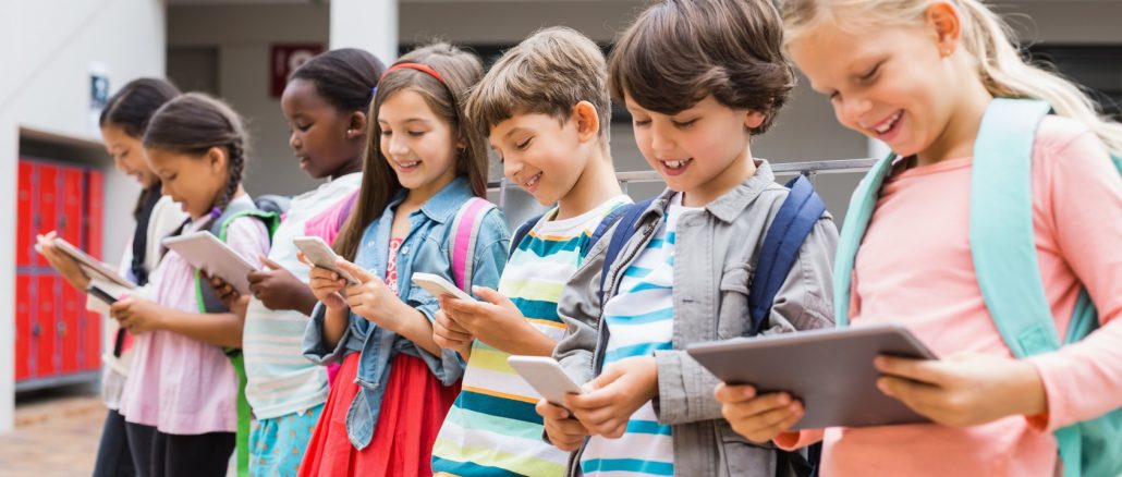 Group of kids using mobile phone and digital tablet