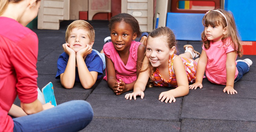 Kindergrtnerin liest Kindern Buch vor